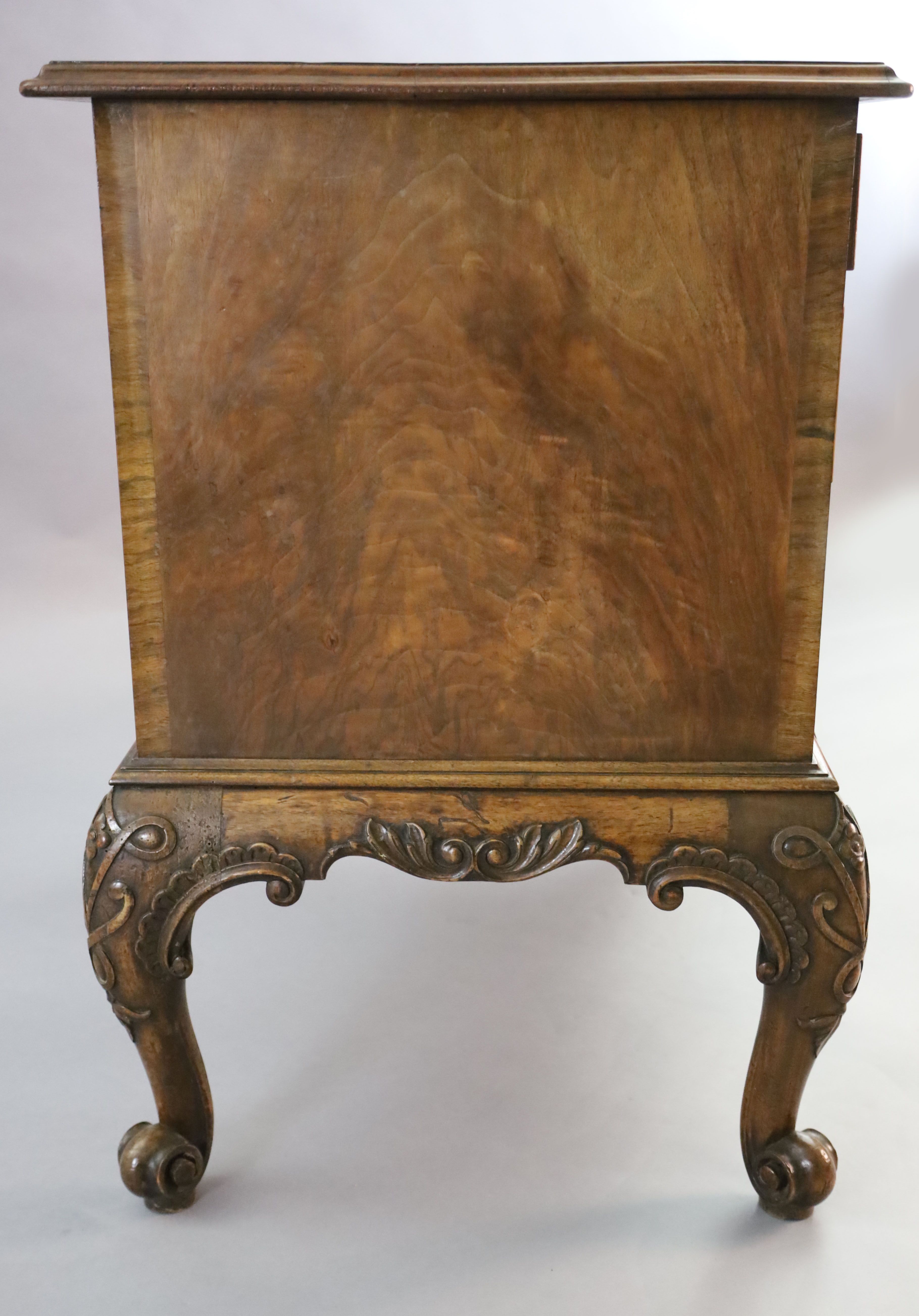 A Georgian style crossbanded walnut chest of three graduated long drawers, W.3ft 1in. D.1ft 10in. H.2ft 8in.